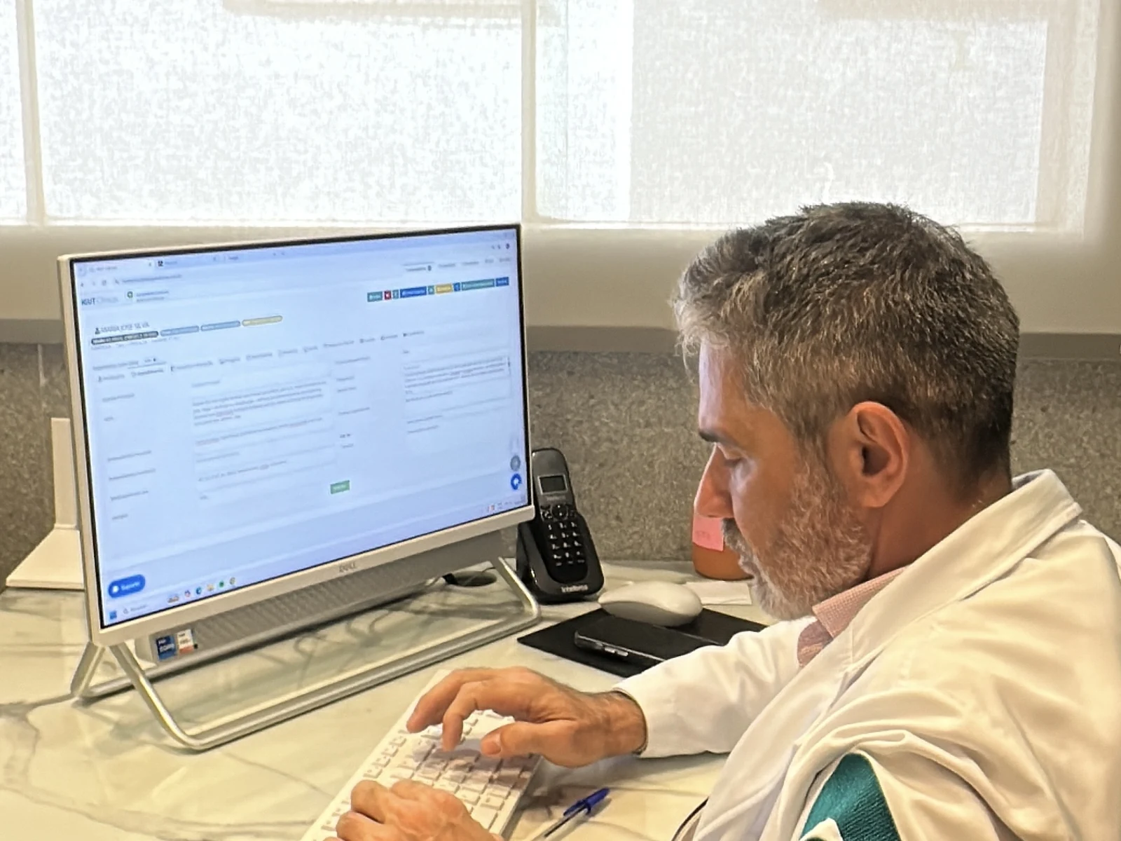 Dr. Alexandre Toulias no consultório, atendendo com tecnologia integrada
